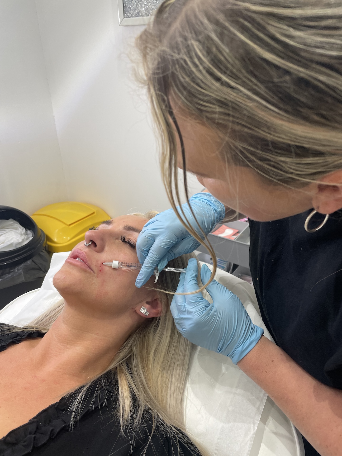 Kerry injecting botox into client with nose piercing