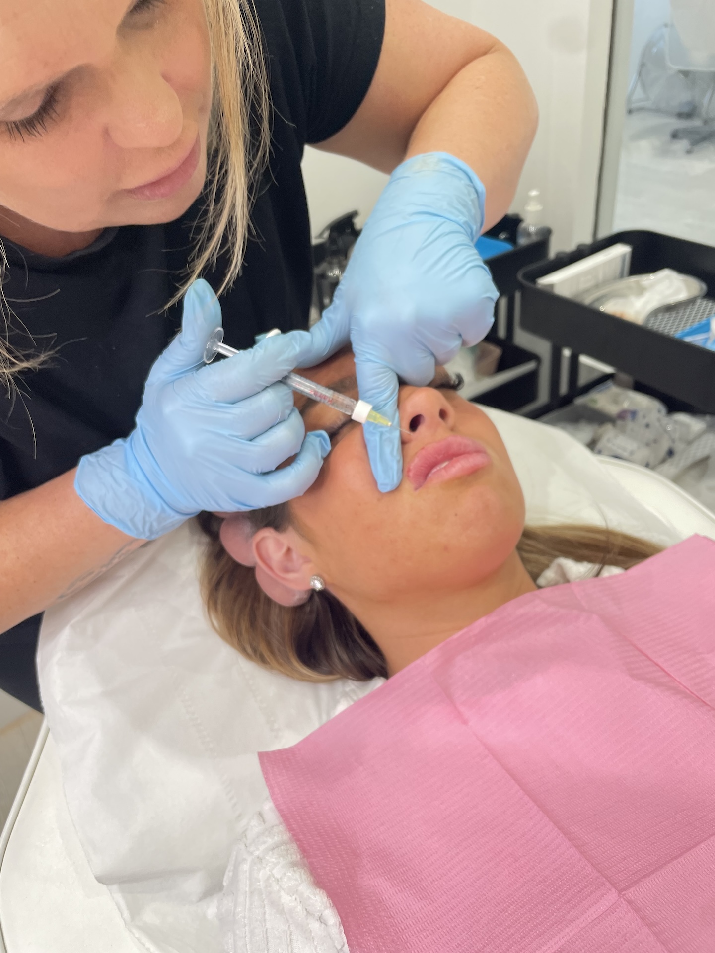 Kerry injecting lip fillers into client